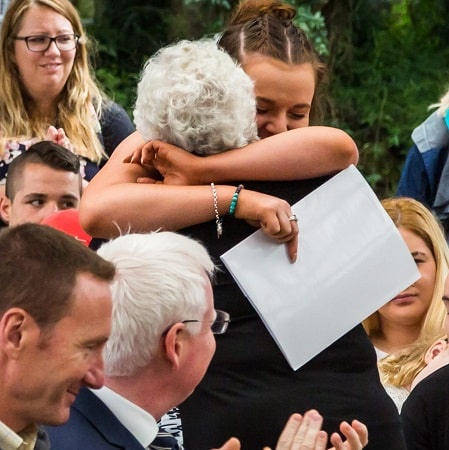 Triple Care Farm graduation ceremony young person hugging mother