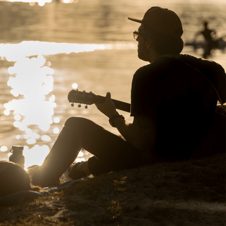 Silhouette of young many playing guitar.