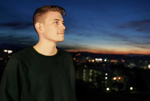 young man looking out at a cityscape at night