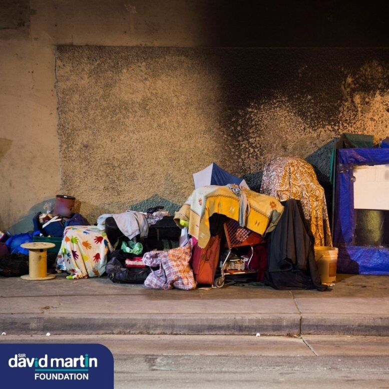 The side of a street with a person's belongings arranged along it