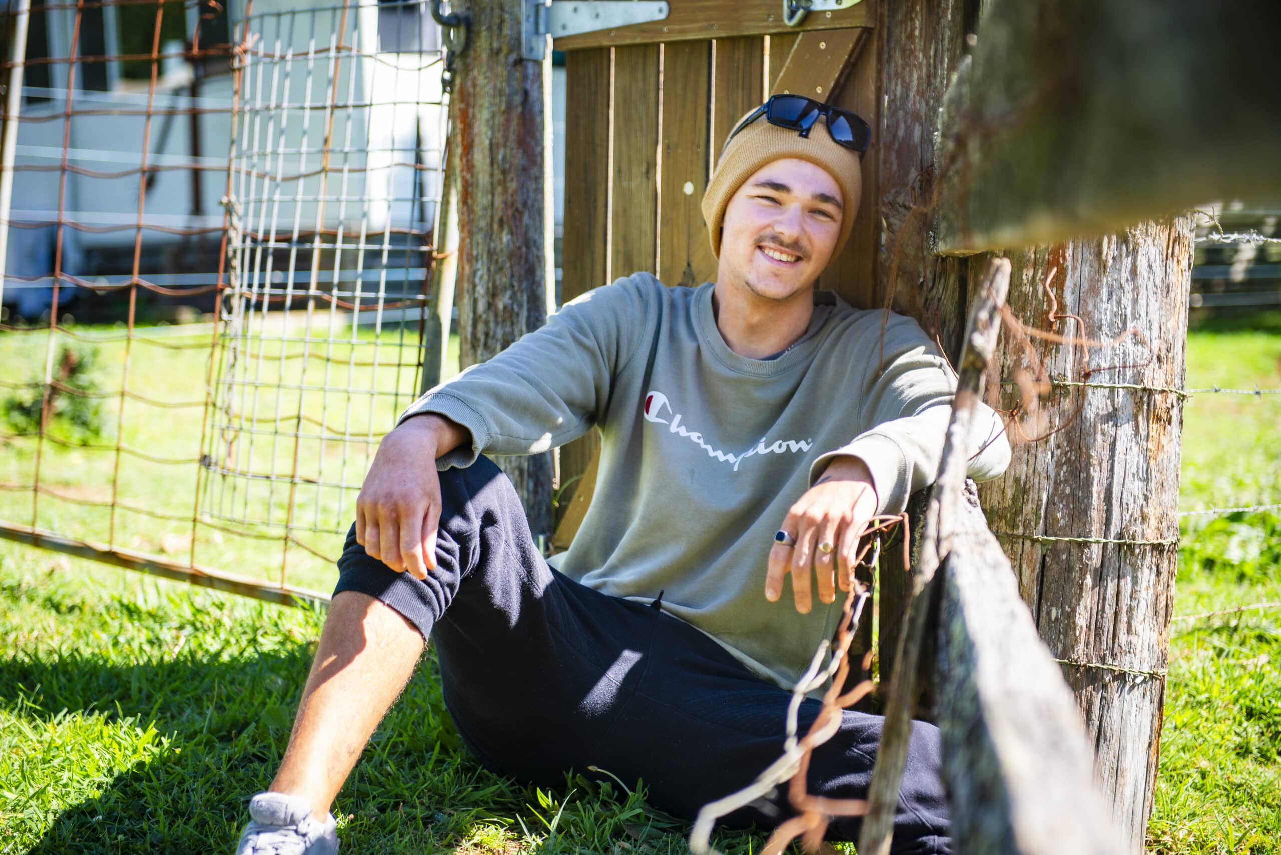 Bailey leans against a fence