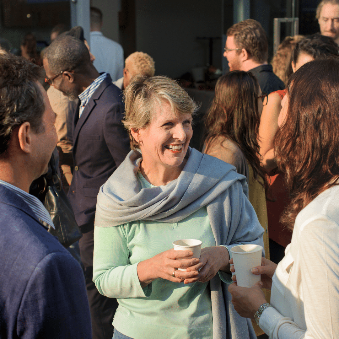 Woman laughing and talking in a crowd of people