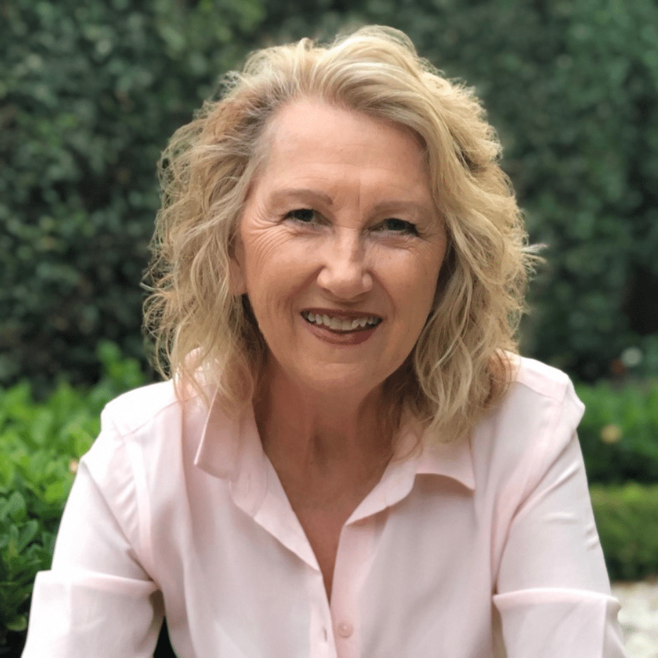 Valerie, an older woman in a collared shirt, smiling.