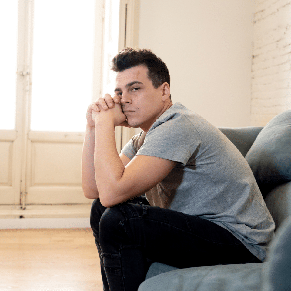 sad young man sitting on a sofa