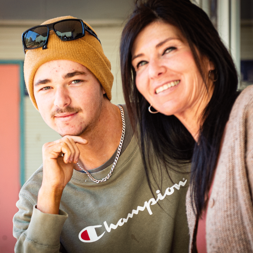 A young man, Bailey, and his mother Joanne smiling and looking in the direction of the camera, hopeful.