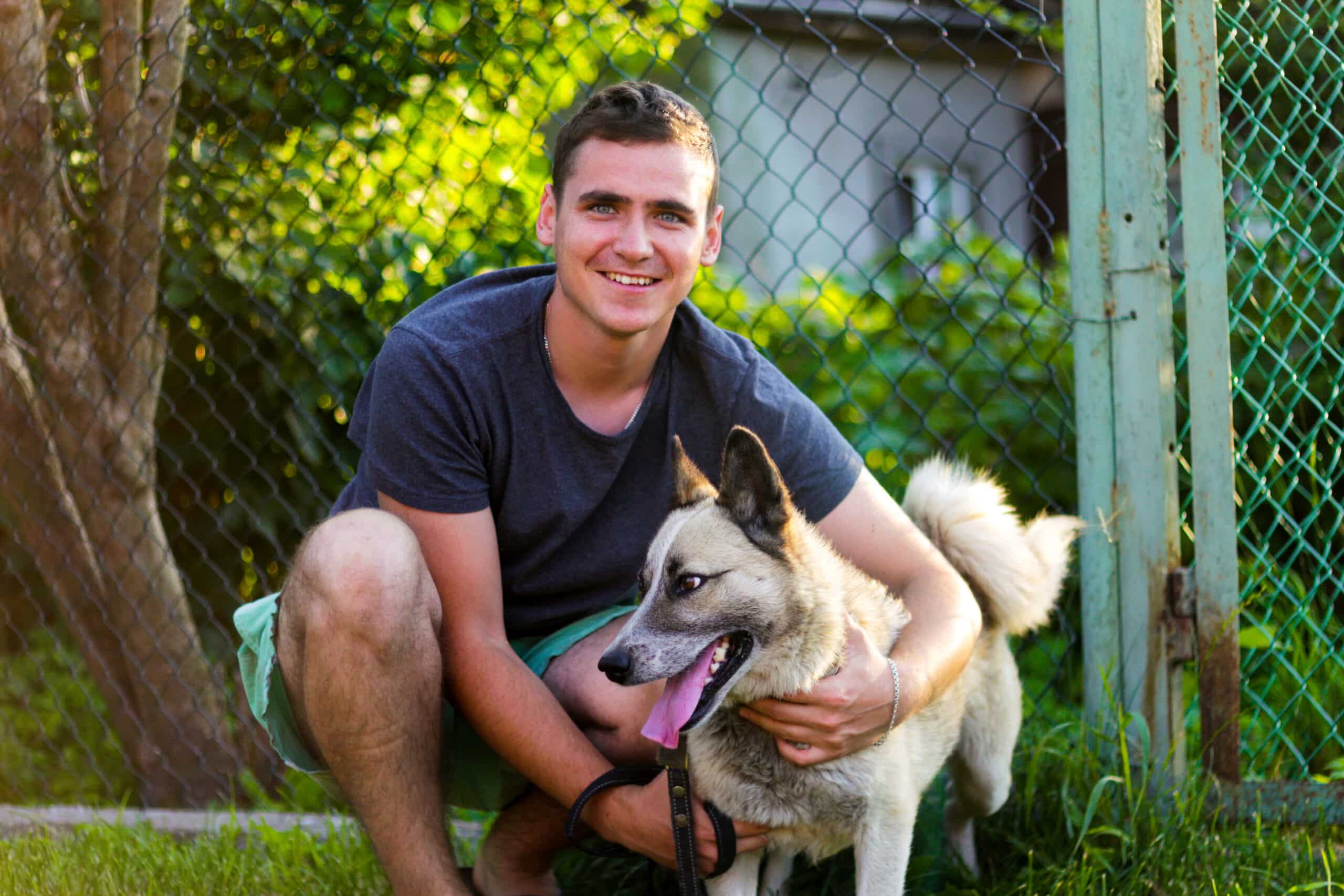 Lucas outside smiling and patting a dog