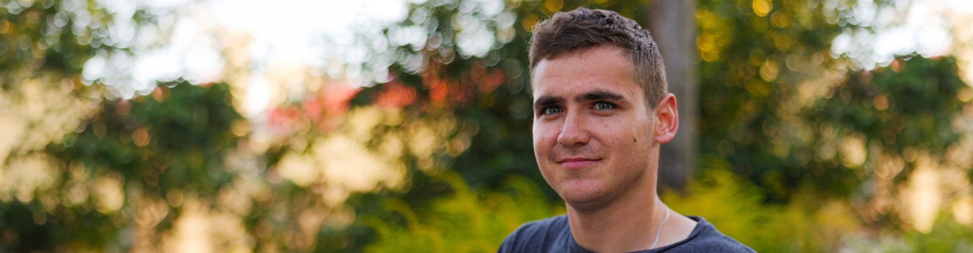 Young man standing outside and looking confidently into the camera lens