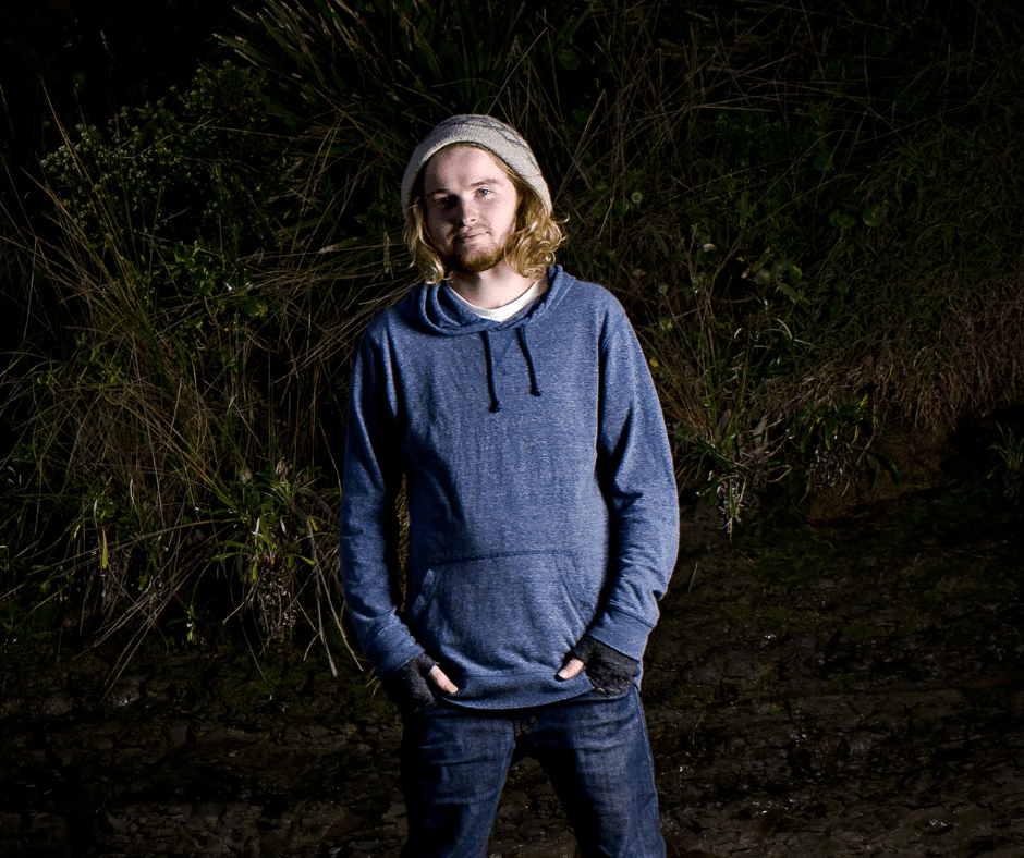 young man standing outside at night