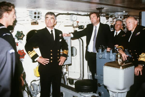 Gunner's Mate First Class V.W. Allen explains operations inside the No. 1 gun turret aboard the battleship USS MISSOURI (BB 63) to Rear Admiral (RDML) (upper half) D.J. Martin, Royal Australian Navy, left; K.C. Beazley, minister of defense, center; and Vice Admiral (VADM) M.W. Hudson, Royal Australian Navy, right. The ship is on a port visit during a cruise around the world.
